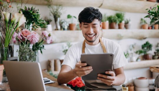 Business professional using a tablet and laptop while working online